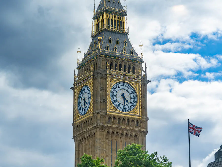 Big Ben against a blue sky with the Union Jack flying beside it