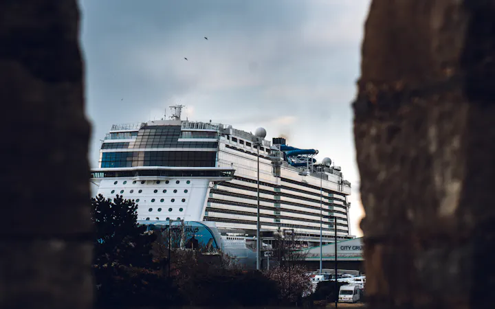 A white cruise ship berthed alongside the terminal