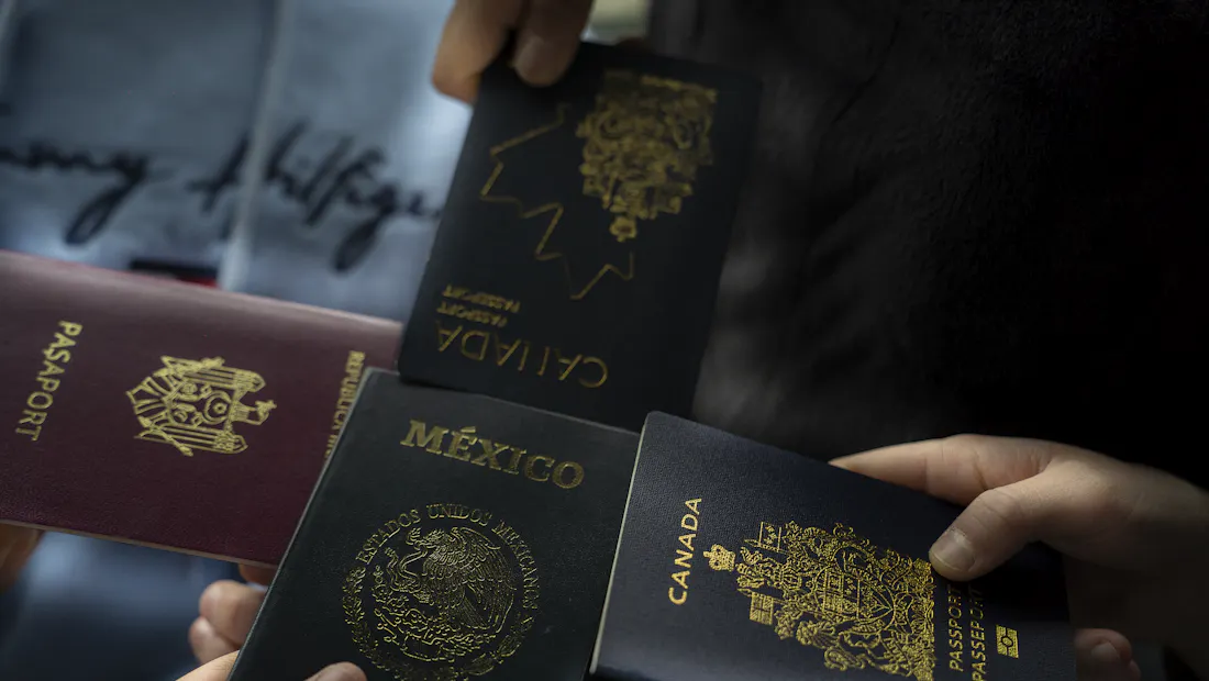 Four passports held up by travellers