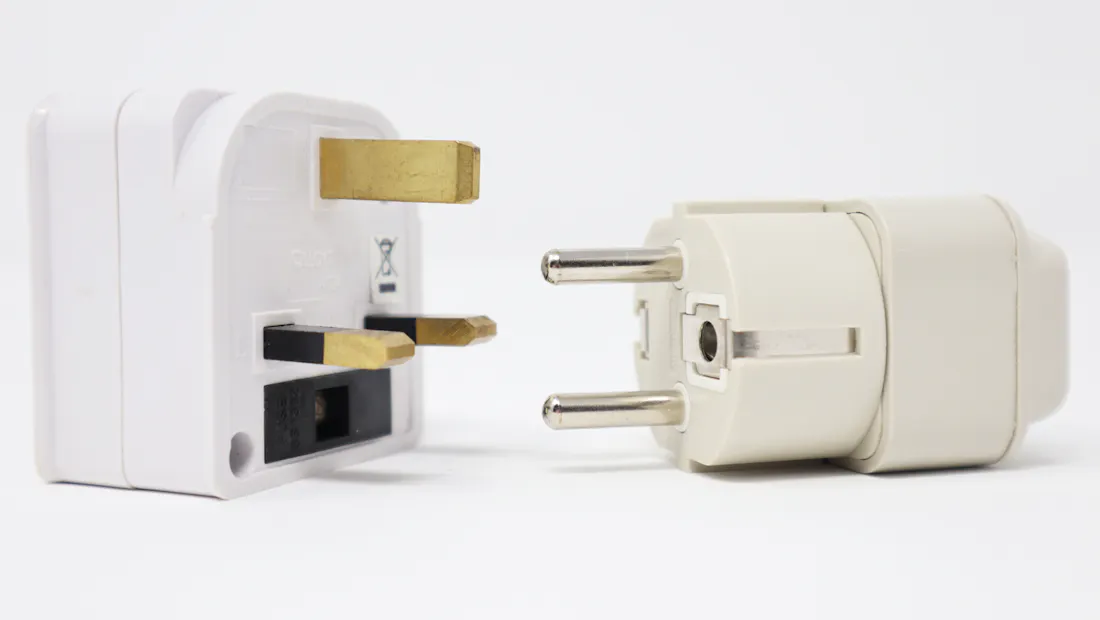 Two white UK three-pin plug adaptors